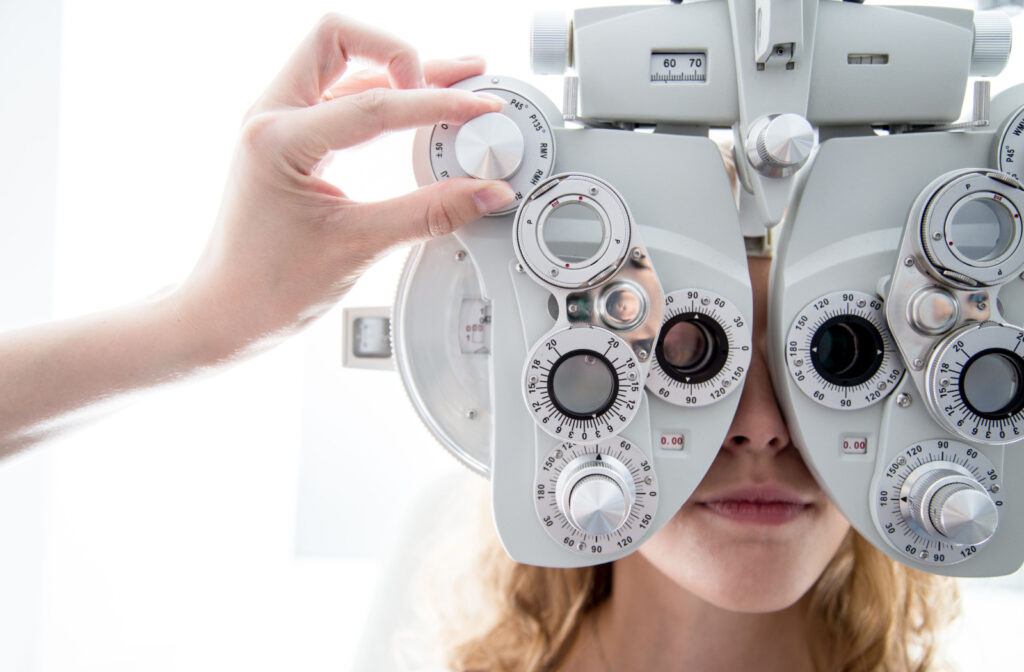 A person at the eye doctor during a refraction test, looking through a phoropter.